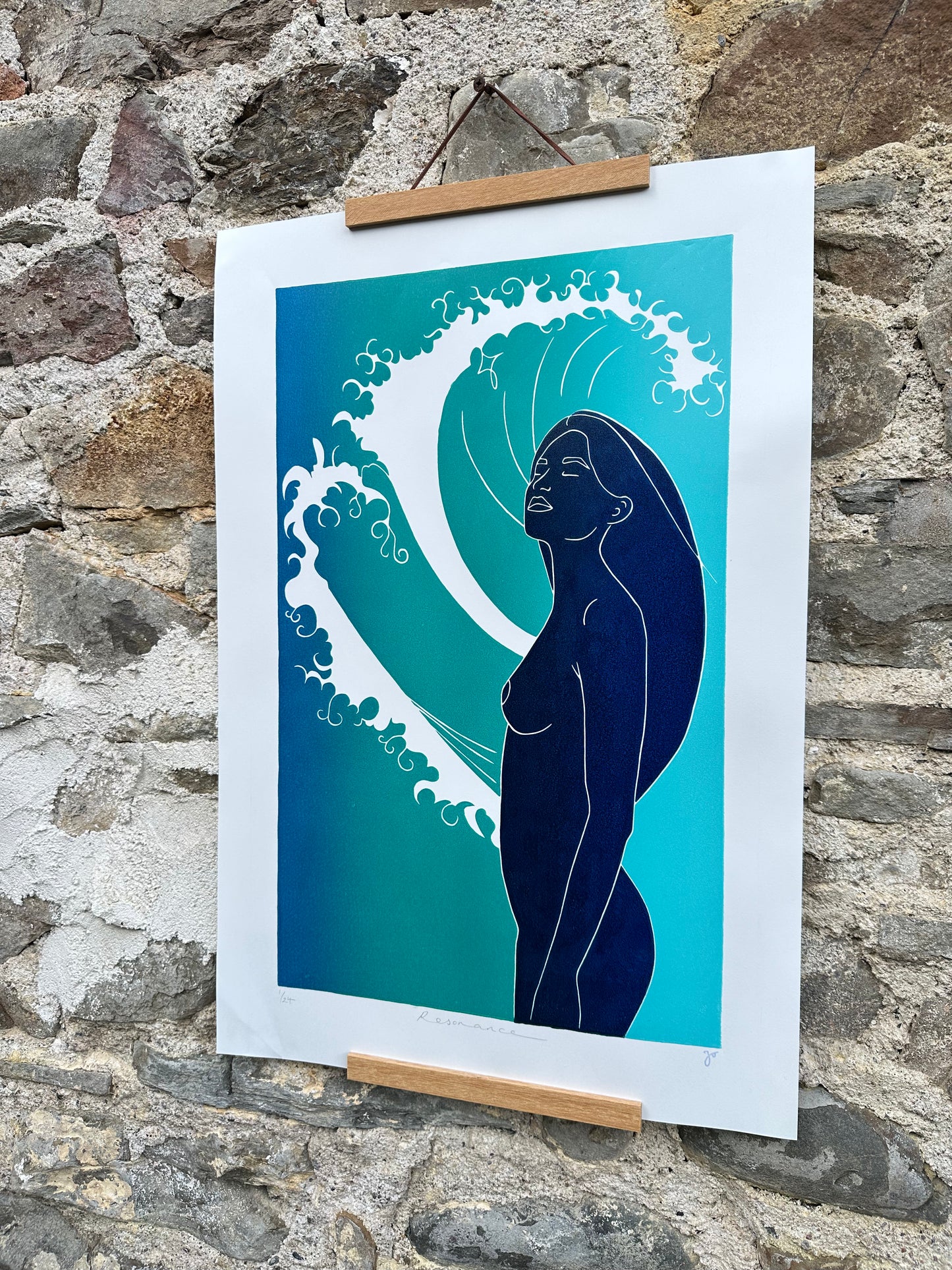 Art print of a woman's silhouette against a wave design on a stone wall